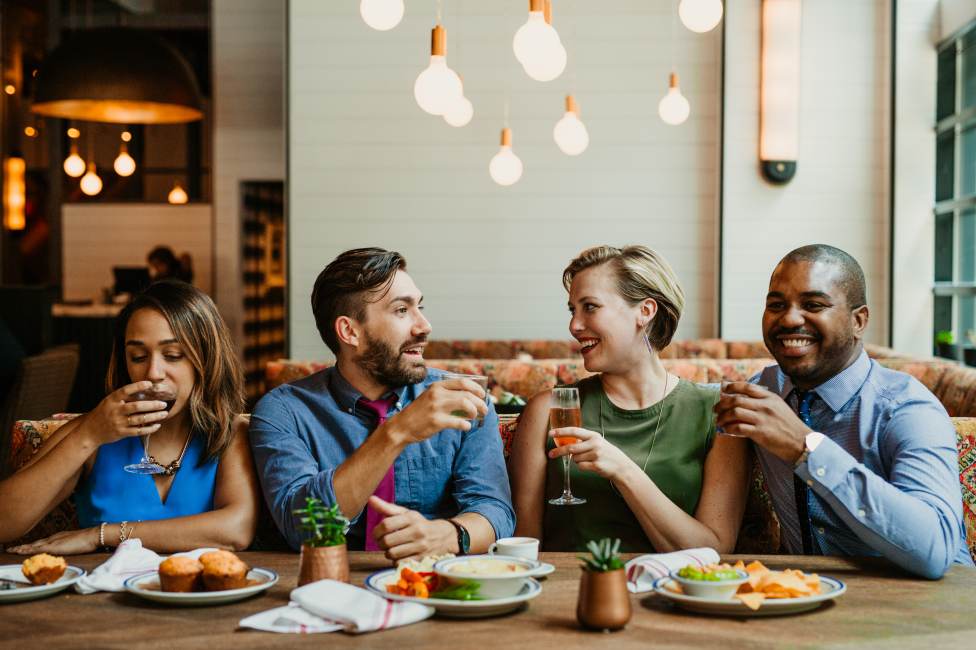 Louisville’s Restaurant Week Offers Community Support for Area Non-Profit Photo of two couples sitting at a restaurant table with food in front of them and cocktails in hand.